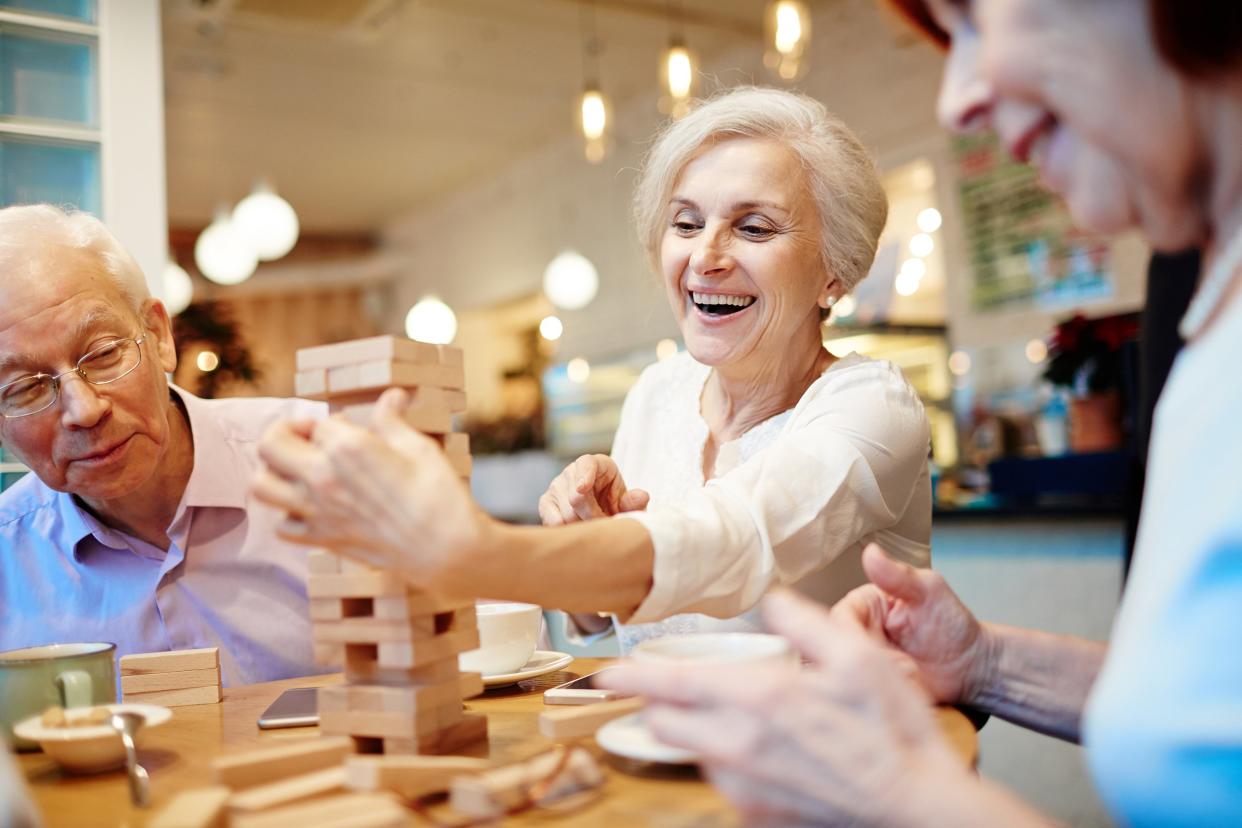 group of seniors playing Jenga in coffee shop