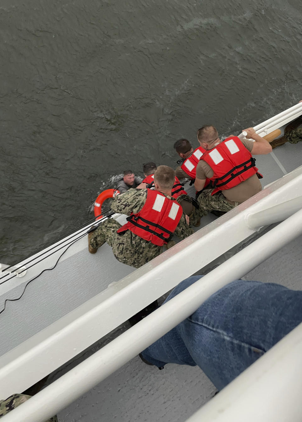 The crew of the Coast Guard Cutter Glenn Harris pulls a person from the water Tuesday, April 13, 2021 after a 175-foot commercial lift boat capsized 8 miles south of Grand Isle, Louisiana. The Coast Guard and multiple other boats rescued six people onboard a commercial lift boat that capsized off the coast of Louisiana on Tuesday night and were searching for more, the agency said. (U.S. Coast Guard Coast Guard Cutter Glenn Harris via AP)