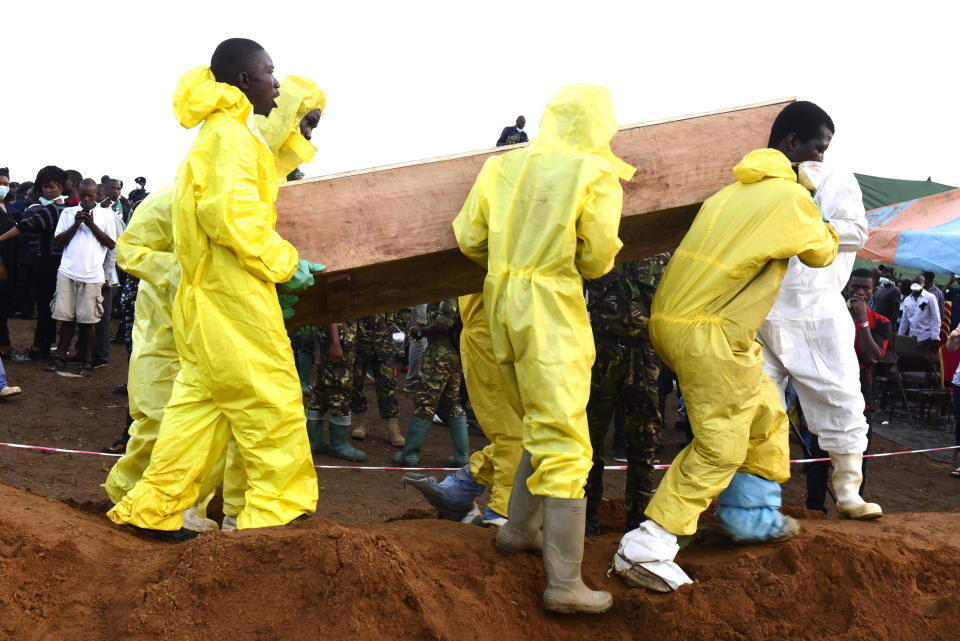 <p>Men carry coffins of mudslide victims on Aug. 17, 2017 at Waterloo cemetery near Freetown, Sierra Leone. (Photo: Seyllou/AFP/Getty Images) </p>