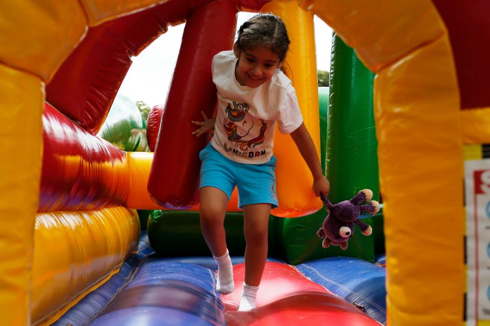 Kids play in a bounce house obstacle course at the Winterville Marigold Festival in downtown Winterville, Ga., on Saturday, May 13, 2023.