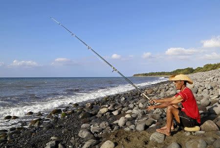 A man fishes on the Jamaique beach in Saint-Denis on the French Indian Ocean island of La Reunion, August 2, 2015. REUTERS/Jacky Naegelen