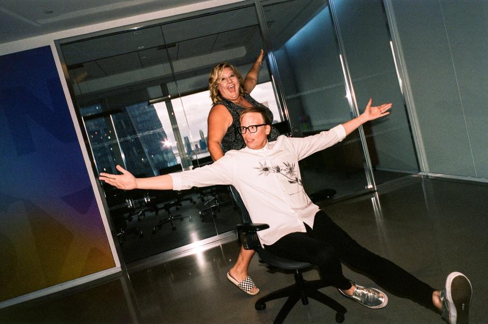 A woman pushes a man on a chair with wheels