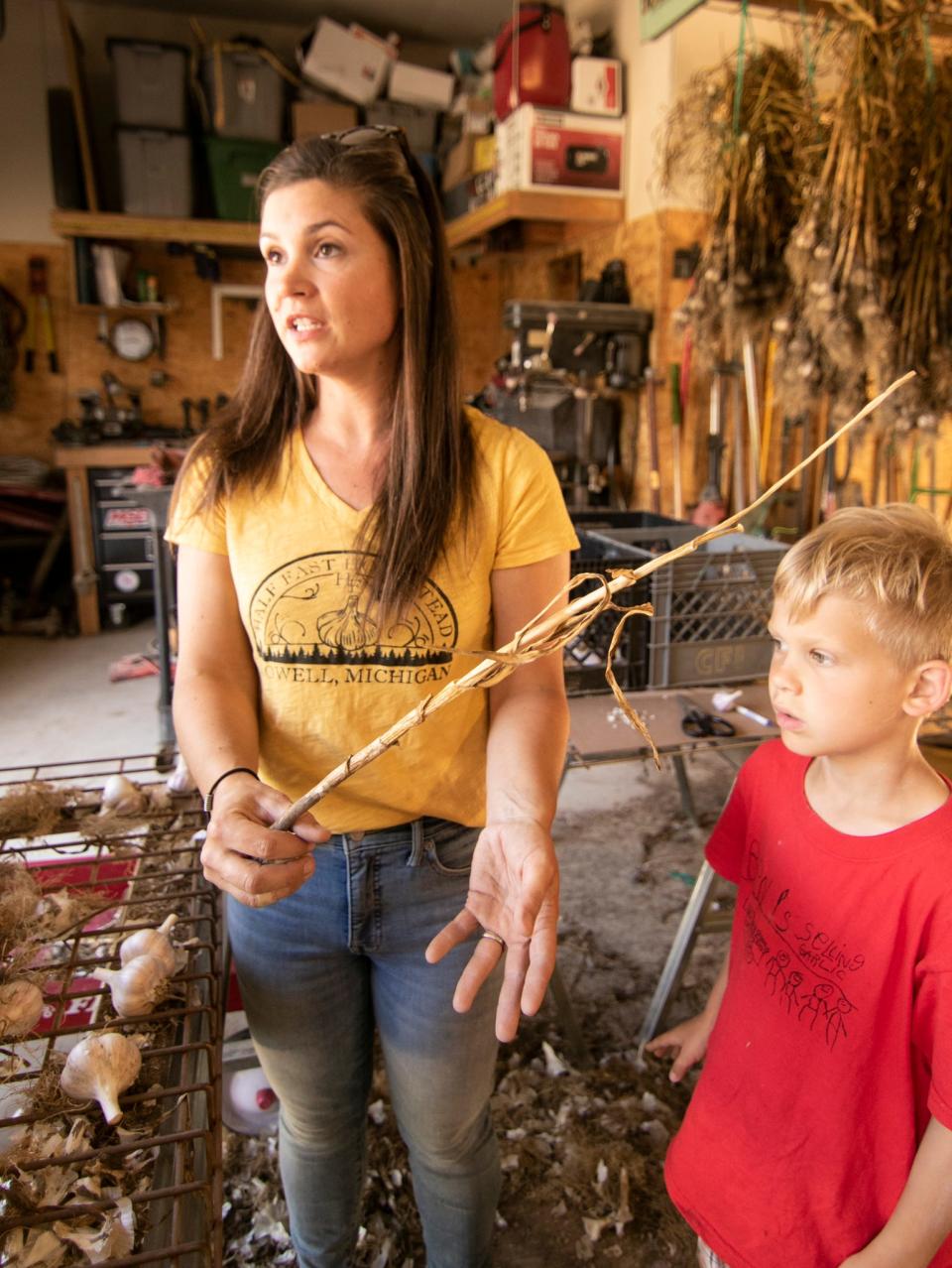 Andrea Sydor explains the process from planting garlic to the processing of it Tuesday, July 26, 2022, as her 6-year-old son Ben offers what he's learned as well.