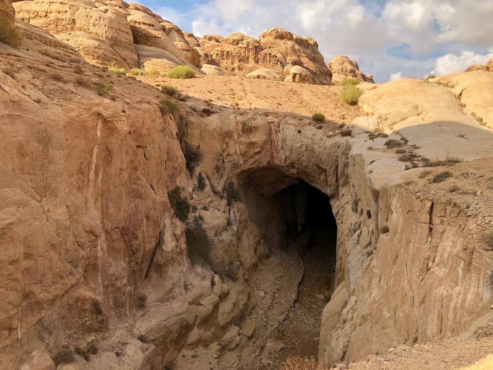 This Thursday, Nov. 15, 2018 photo, shows an ancient tunnel that was built to protect the area from flooding, in Petra, Jordan. In ancient times, Arab tribesmen protected their trading post of Petra against desert flash floods with diversion tunnels. Today, an alarm system warns visitors when flood water rushes toward what has become Jordan's main tourist attraction. (AP Photo/Laure Van Ruymbeke)