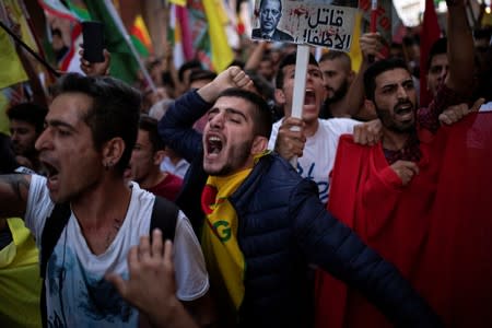 Kurds living in Greece shout slogans during a demonstration against Turkey's military action in northeastern Syria, in Athens