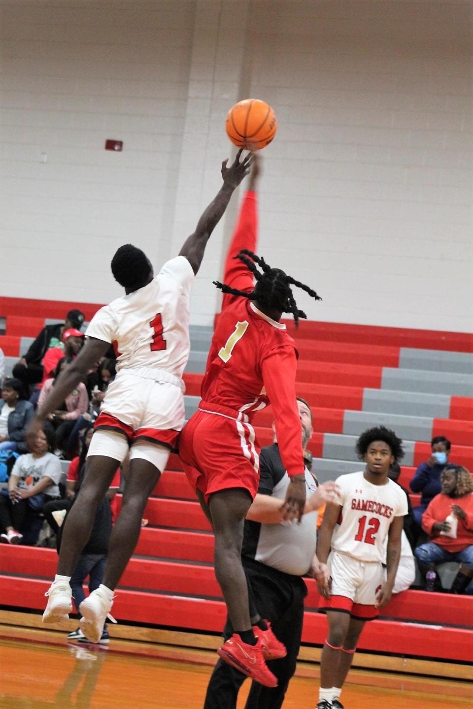 Ty Lanier (1 in white) of SCHS and Quan Proctor (1 in red) of MCA battle for the opening tip in Saturday night's Gamecock 55-51 upset.