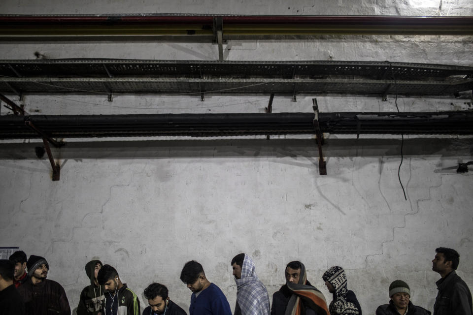 In this picture taken Thursday Dec. 12, 2019 a group of migrants, mostly form Pakistan and Afghanistan line for food at a temporary reception centre set up by the IOM (International Organization for Migrants) in Bihac, northwestern Bosnia. Bosnia's notorious Vucjak camp may have closed down after an international outcry, but the plight of migrants stranded in the country while trying to reach Western Europe is far from over. After the camp was flattened in December, its residents have been transferred to other parts of Bosnia. But some have returned to Bihac because it is near the European Union member state Croatia. (AP Photo/Manu Brabo)