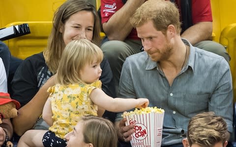 Butter wouldn't melt... as Emily is rumbled pinching Prince Harry's popcorn - Credit: Samir Hussein/WireImage