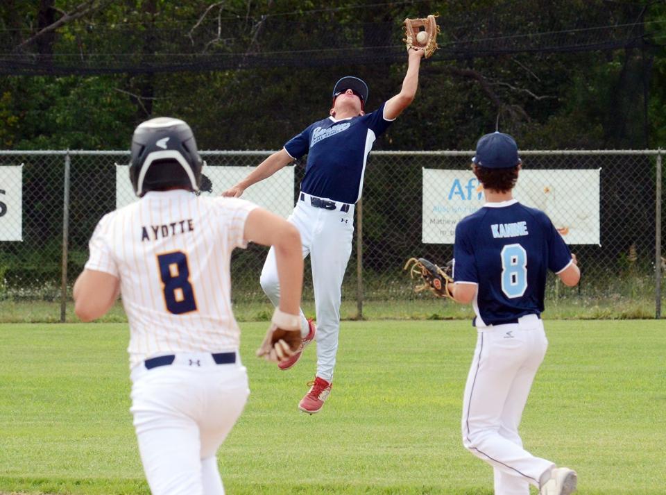 Petoskey's Lukas Nemec makes a leaping catch for an out at shortstop, as Brady Kanine watches against Negaunee over the weekend.