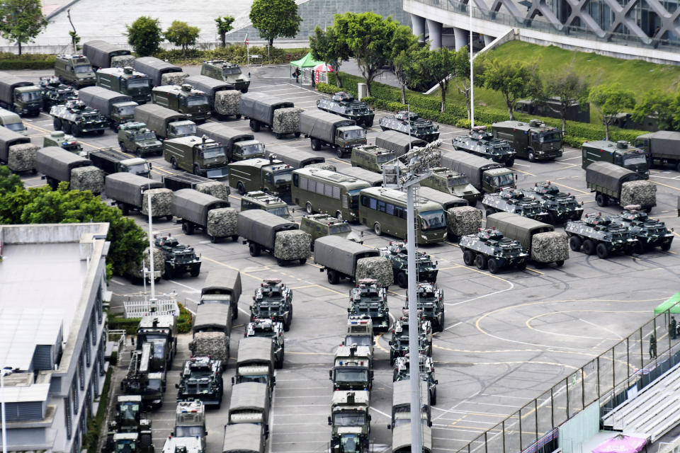 This Friday, Aug. 16, 2019, photo shows armored vehicles and troop trucks are parked outside Shenzhen Bay Stadium in Shenzhen, China. Members of China's paramilitary People's Armed Police marched and practiced crowd control tactics at a sports complex in Shenzhen across from Hong Kong on Friday, in what some interpreted as a threat against pro-democracy protesters in the semiautonomous territory.(Madoka Ikegami/Kyodo News via AP)