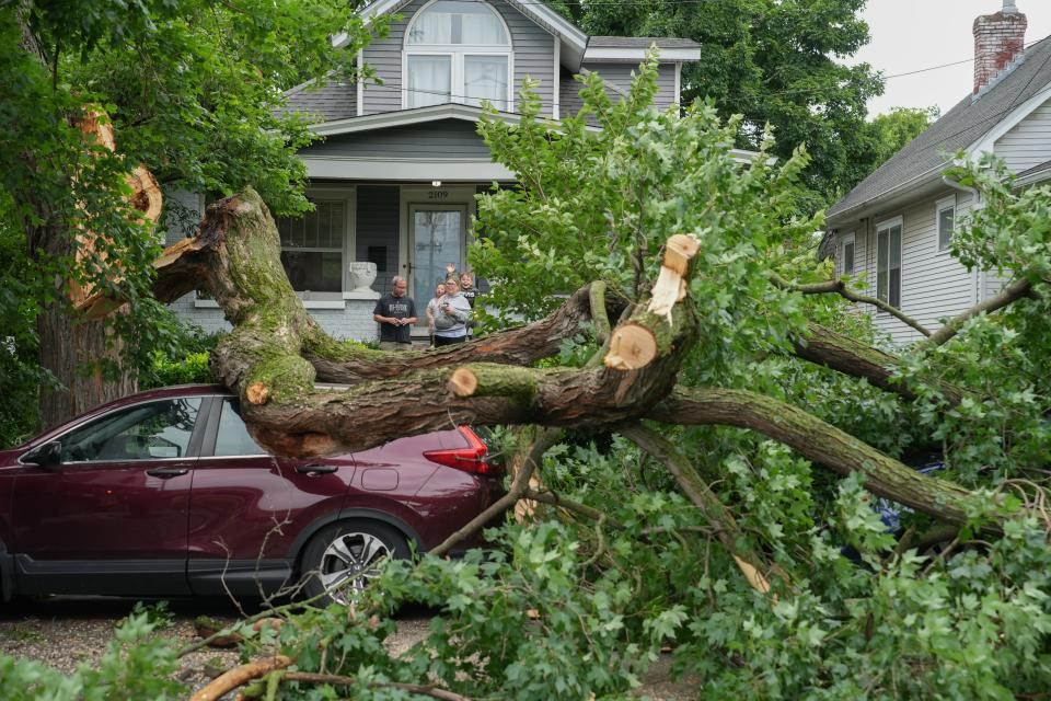 The Hyman’s watch as a tree is removed from on top of their cars on Wrocklage Ave. after a storm came through Louisville, Ky on Sunday, May 26, 2024.
