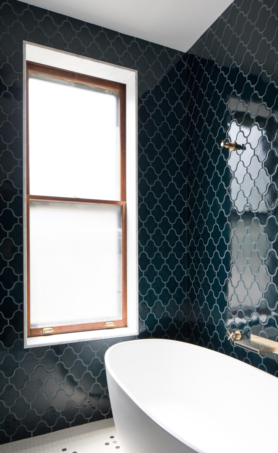 A bathroom with shiny blue tiles