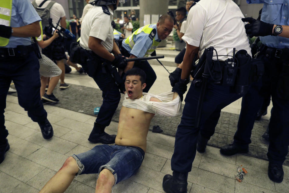 Hong Kong police officers drag away a battered protester. source: AP