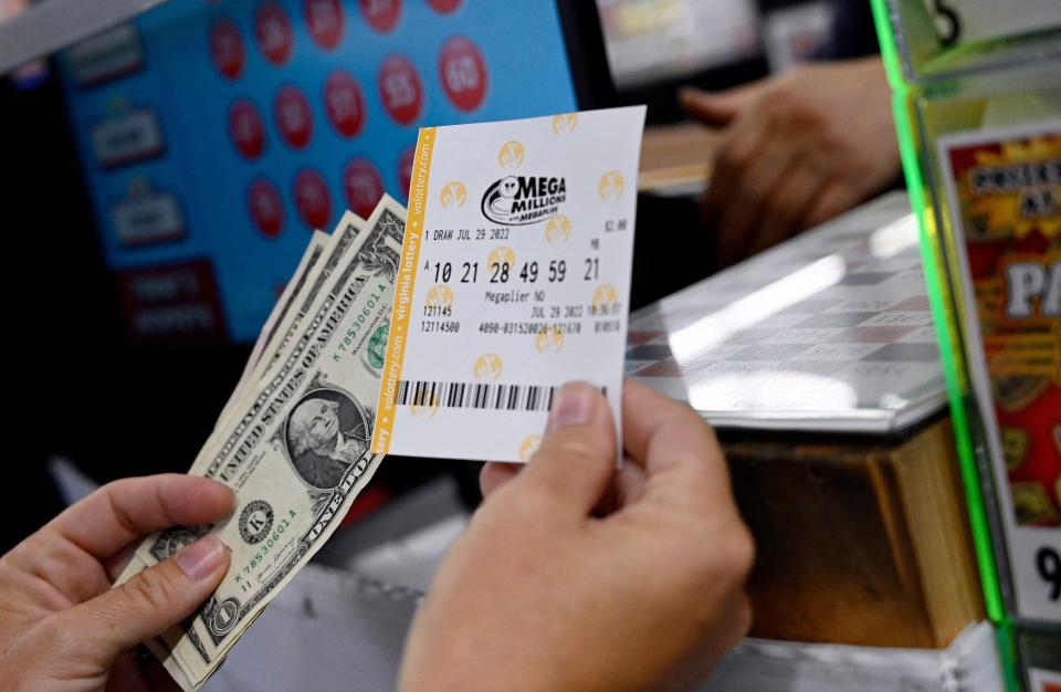 A person buys a Mega Millions lottery ticket at a store on July 29, 2022 in Arlington, Virginia.