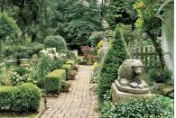 <p>Lush ornamentals and edibles were planted between the straight lines of paths in this Ohio garden, which artfully bind yard to house. Clipped boxwood and arborvitae, and a century-old stone lion, carved by an Ohio folk artist, define open-air rooms. White phlox and daisies bloom by the picket-fenced vegetable patch. </p>