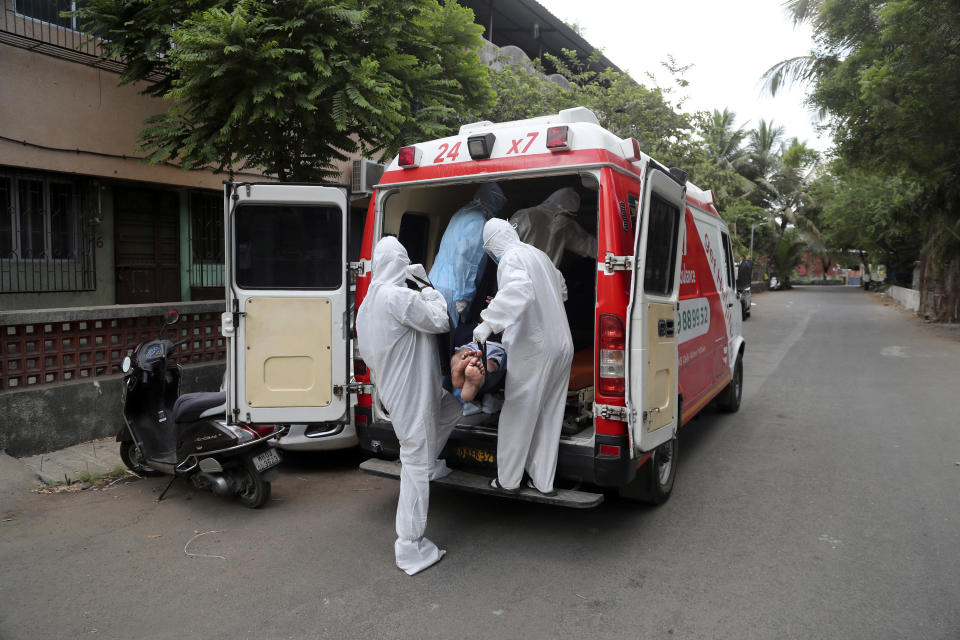 Izhaar Hussain Shaikh, left, an ambulance driver who works for HelpNow, an initiative to help the stretched services of first responders, picks up a COVID-19 patient from his home in Mumbai, India May 28, 2020. It’s an exhausting job and Shaikh's daily shifts are grueling, sometimes even stretching to 16 hours. For a city that has a history of shortage of ambulances and where coronavirus pandemic has claimed hundreds of lives, putting the health care system under immense strain, every help counts. (AP Photo/Rafiq Maqbool)