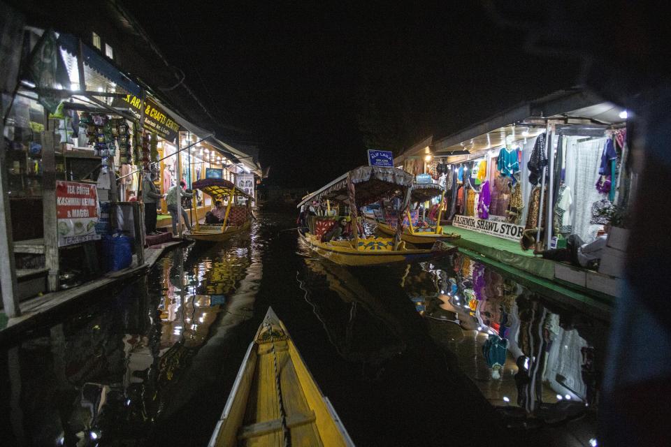 A Kashmiri boatman rows his boat carrying Indian tourists at a market in the interior of Dal Lake in Srinagar, Indian controlled Kashmir on Aug. 2, 2021. Tourists are returning to the valleys and mountains in Indian-controlled Kashmir, as infections in the Himalayan region and nationwide come down after a deadly second wave earlier this year. (AP Photo/Mukhtar Khan)