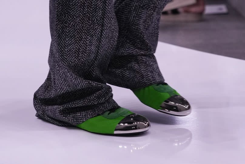 Model struts in dazzling green shoes from the Prada Spring-Summer 2025 collection.