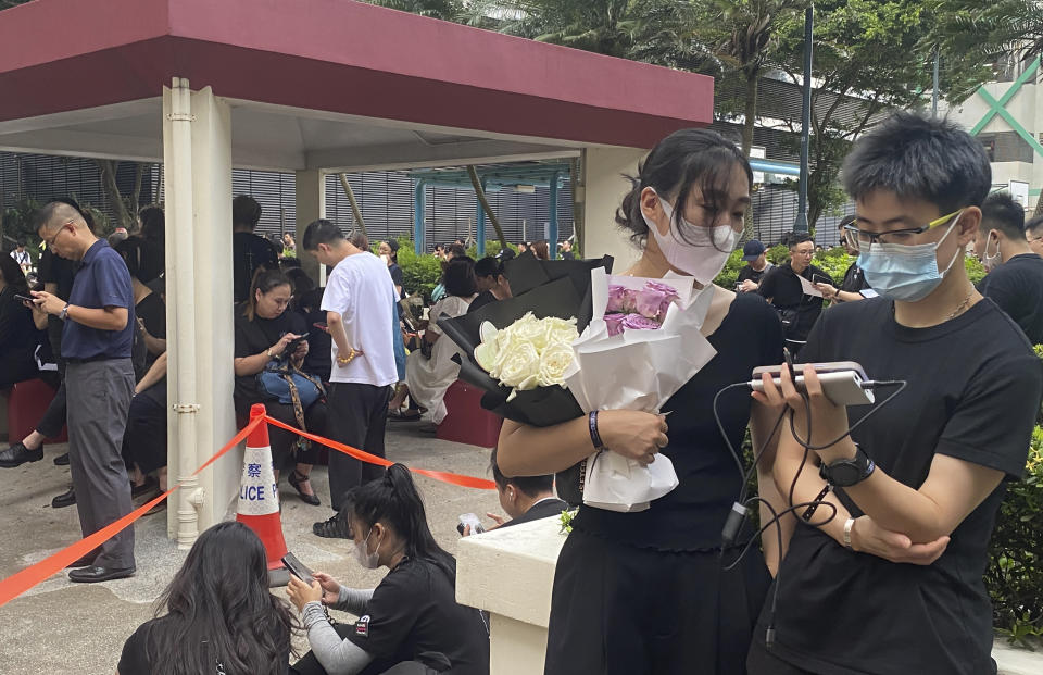 Fans line up near the Hong Kong Funeral Home, where a funeral is set up for Hong Kong singer and songwriter Coco Lee, in Hong Kong on Monday, July 31, 2023. Fans of singer and songwriter Coco Lee, who was known for her powerful voice and live performances, were gathering with flowers to pay their respects at her funeral in Hong Kong. (AP Photo/Annie Cheung)