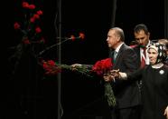 <p>Turkish Prime Minister Tayyip Erdogan throws flowers to his supporters next to his wife Emine during his visit in Cologne May 24, 2014. (Wolfgang Rattay/Reuters) </p>