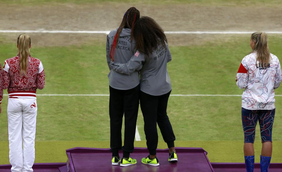 Serena Williams (center, R) and her sister Venus Williams, of the U.S., stand on the podium with their gold medals during the presentation ceremony for the women's doubles tennis at the All England Lawn Tennis Club during the London 2012 Olympic Games August 5, 2012. REUTERS/Adrees Latif (BRITAIN - Tags: OLYMPICS SPORT TENNIS TPX IMAGES OF THE DAY)