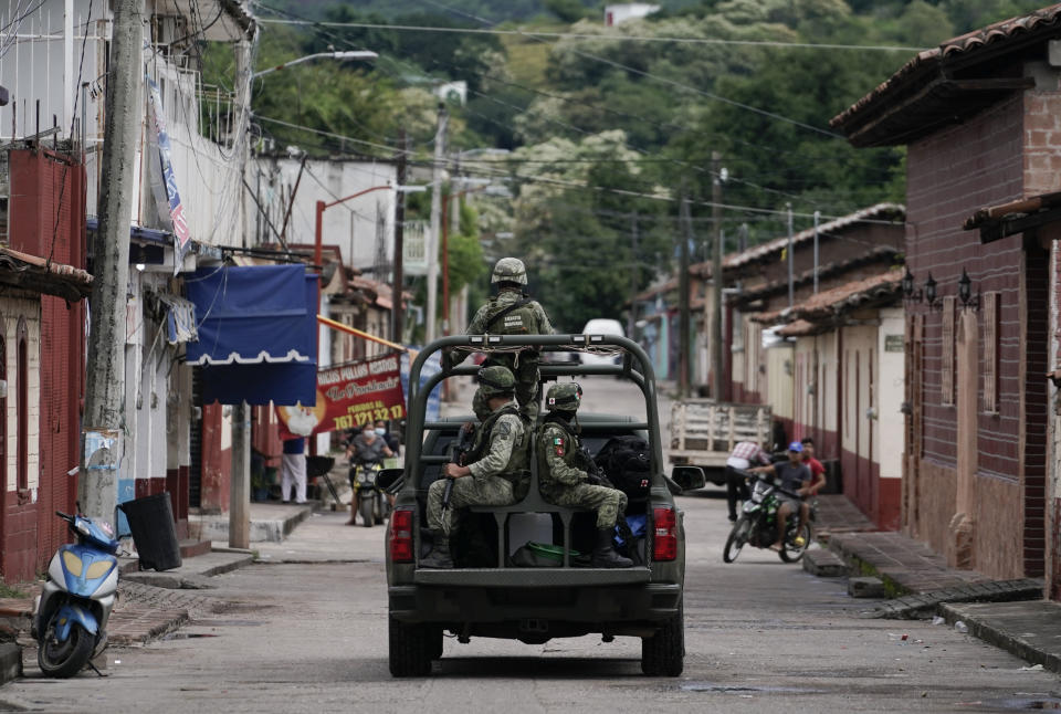 Soldier patrol in San Miguel Totolapan after a mass shooting, in Mexico, Thursday, Oct. 6, 2022. A drug gang burst into the town hall and shot to death 20 people, including a mayor and his father, officials said Thursday. (AP Photo/Eduardo Verdugo)