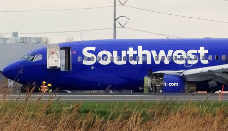 Emergency personnel monitor the damaged engine of Southwest Airlines Flight 1380, which diverted to the Philadelphia International Airport this morning after the airline crew reported damage to one of the aircraft's engines, on a runway in Philadelphia, Pennsylvania U.S. April 17, 2018. REUTERS/Mark Makela