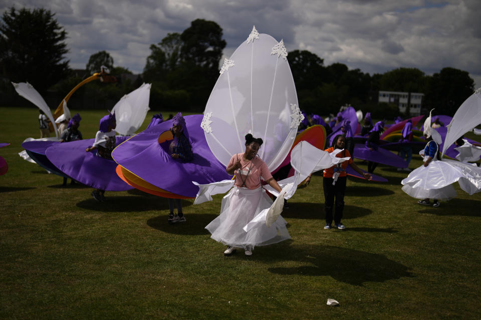 Members of the Mahogany carnival group take part in a rehearsal for their upcoming performance at the Platinum Jubilee Pageant, at Queens Park Community School, in north London, Saturday, May 28, 2022. Britain is getting ready for a party featuring mounted troops, solemn prayers — and a pack of dancing mechanical corgis. The nation will celebrate Queen Elizabeth II’s 70 years on the throne this week with four days of pomp and pageantry in central London. (AP Photo/Matt Dunham)