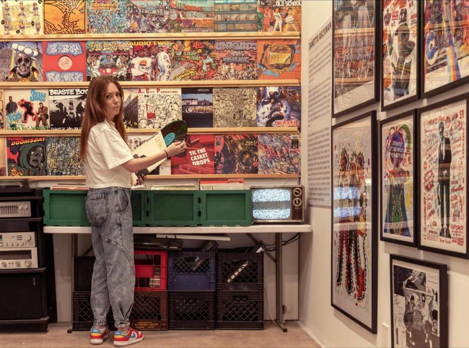 Museum co-founder Allison Freudian looks at albums in crates in the installation displaying early hip-hop recordings.