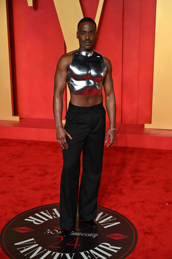 Individual on red carpet in metallic top and black pants