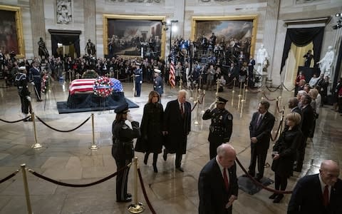 Donald Trump and his wife Melania depart the US Capitol Rotunda, where former US president George H W Bush is lying in state - Credit: Jabin Botsford/Pool via Bloomberg