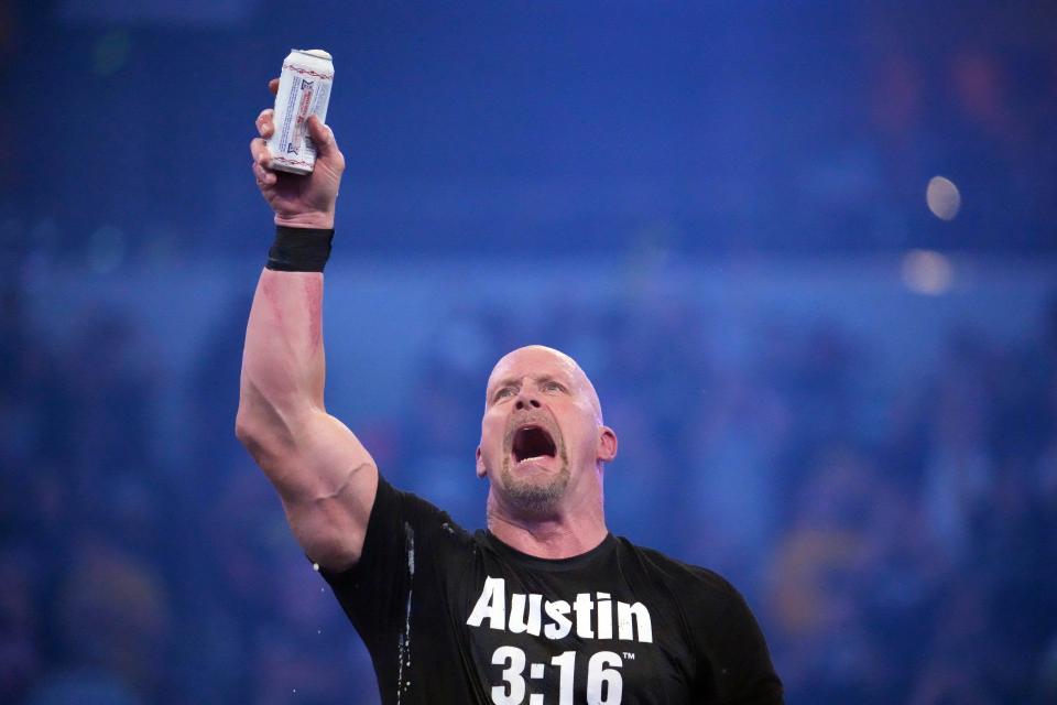 Stone Cold Steve Austin celebrates with beer after defeating Kevin Owens.