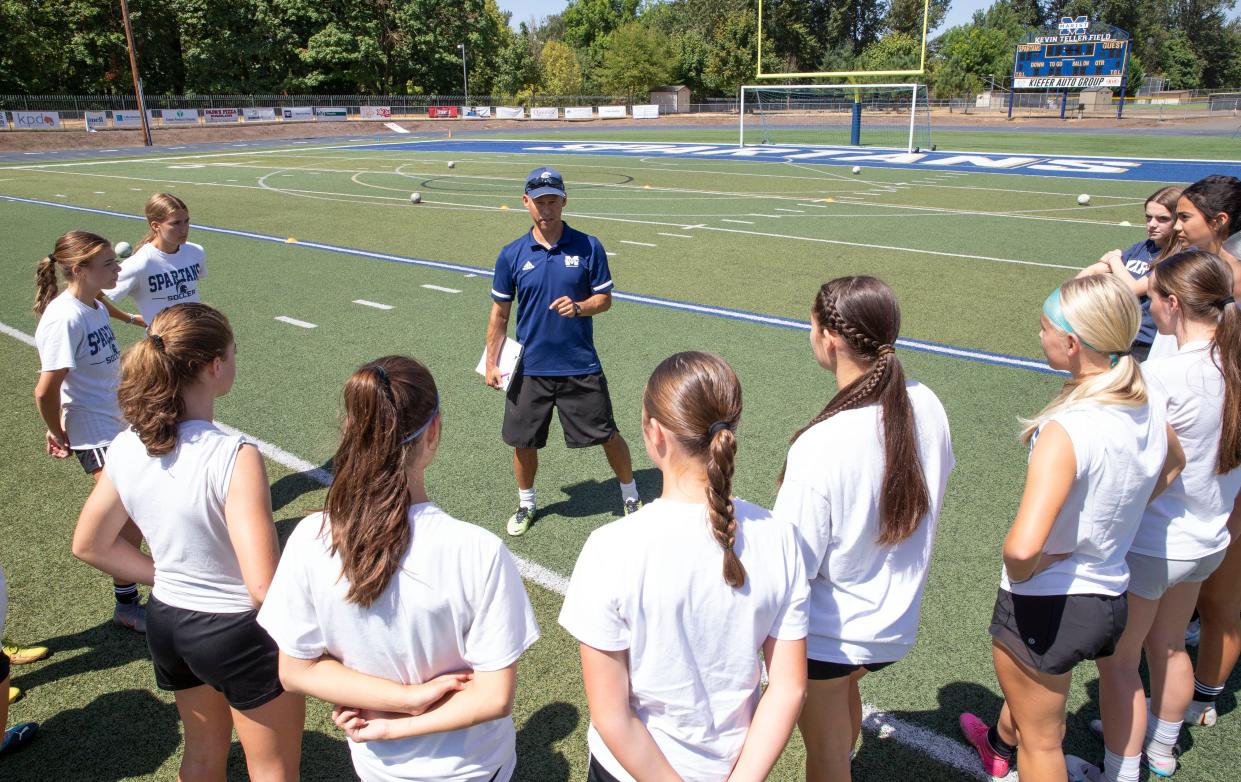 Marist girls soccer coach Stefan Schroffner, center, gathers his team as they prepare for the 2023 season.