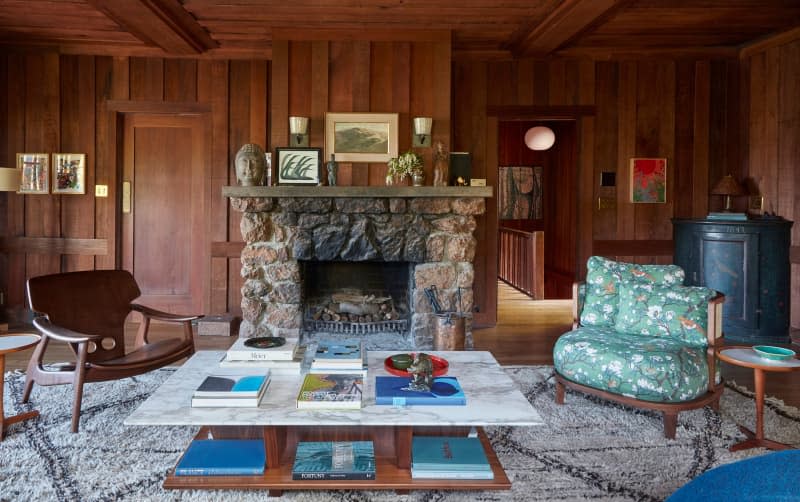 Fireplace in wood paneled living room.