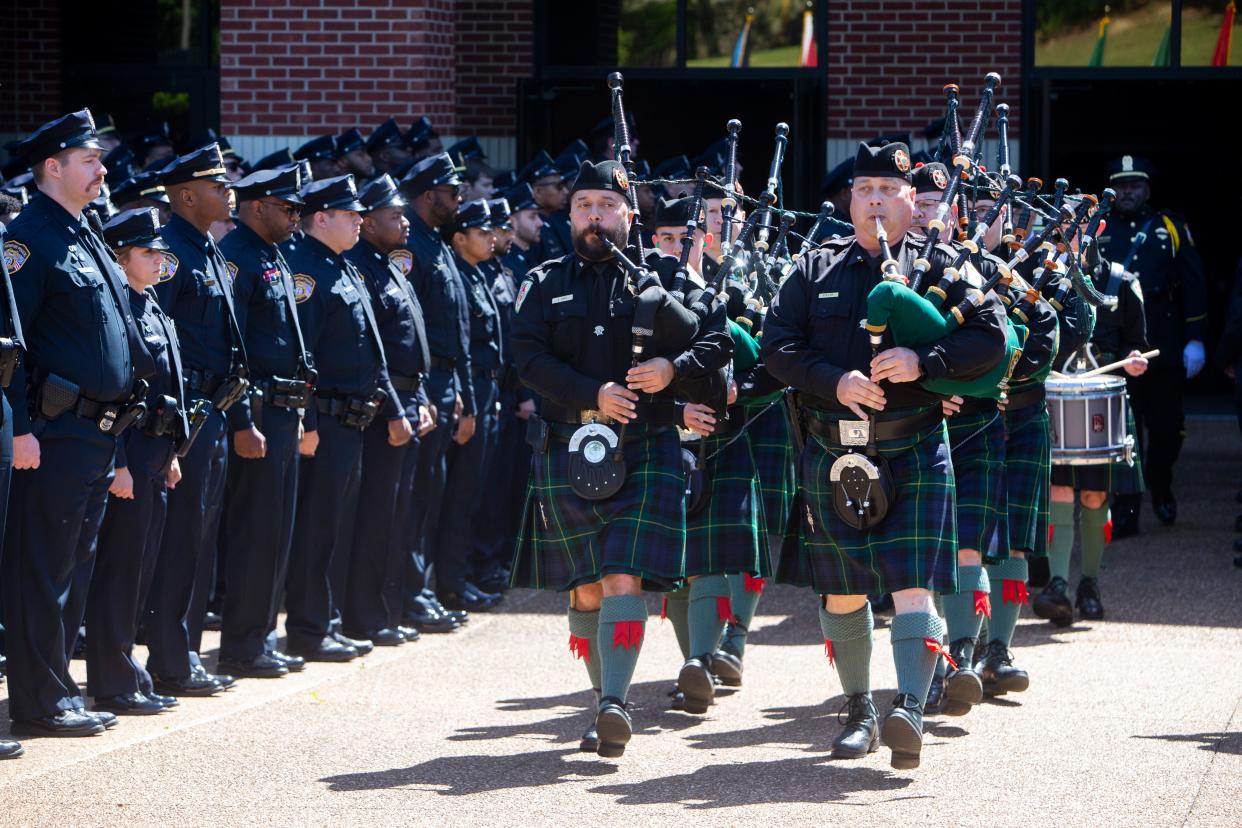 A Scottish bagpipe band leads the casket of Joseph McKinney, a Memphis Police Department officer who was killed during a shootout on April 12, out of Hope Church after his funeral in Cordova, Tenn., on Monday, April 22, 2024.