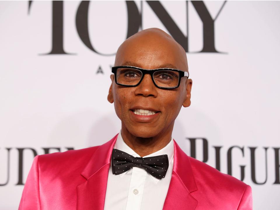 RuPaul Charles out of drag in a pink suit a bowtie