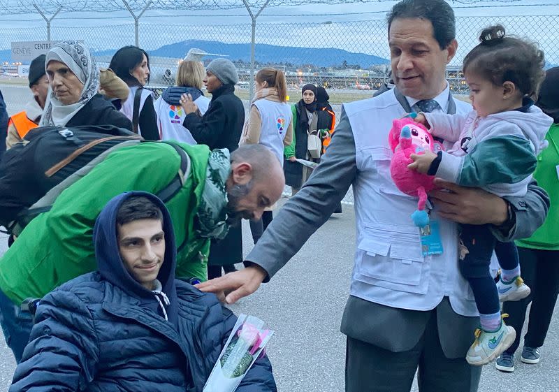 Geneva-based doctor Raouf Salti holds 17-month-old Zeina, next to 16-year-old Yussef, both of whom were evacuated from Gaza to Switzerland to receive medical treatment, at Geneva airport