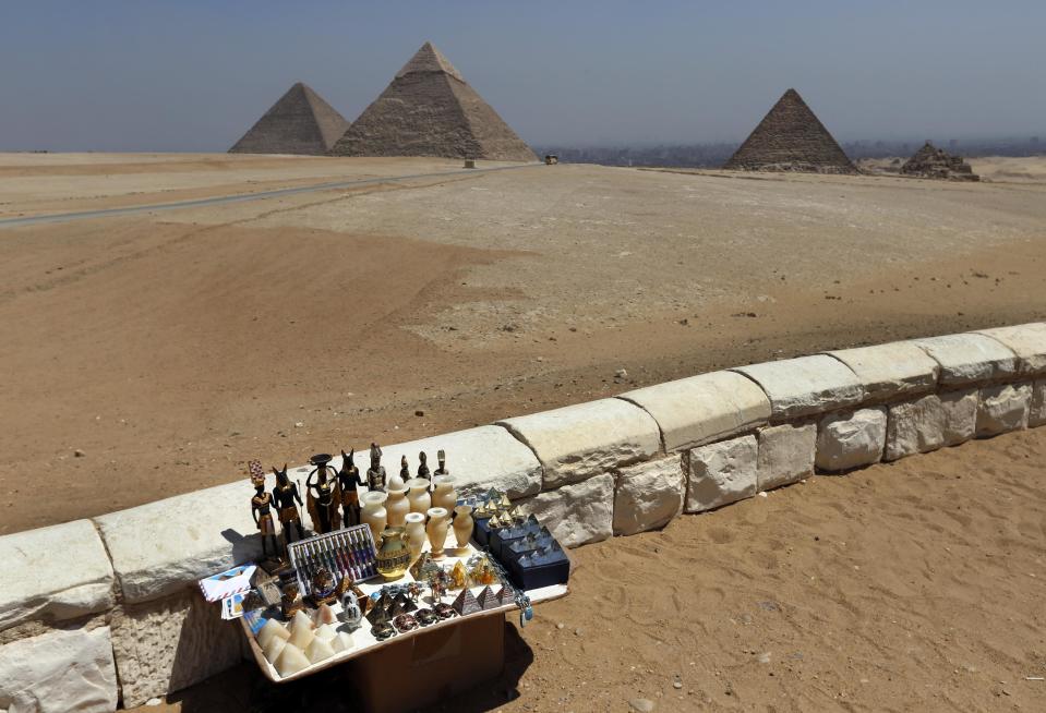 In this Saturday, Sept. 7, 2013 photo, souvenirs are displayed for sale on a vendor's bench at the historical site of the Giza Pyramids, near Cairo, Egypt. Before the 2011 revolution that started Egypt's political roller coaster, sites like the pyramids were often overcrowded with visitors and vendors, but after a summer of coup, protests and massacres, most tourist attractions are virtually deserted to the point of being serene. (AP Photo/Lefteris Pitarakis)