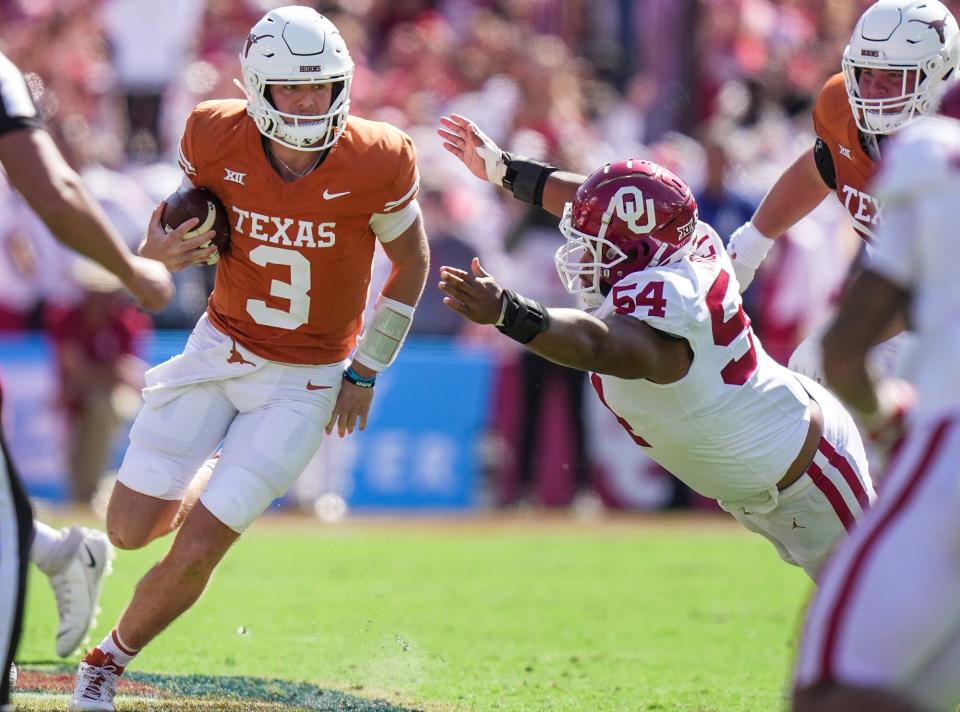 Texas Longhorns quarterback Quinn Ewers (3) looks for too to run as he avoids contact with Oklahoma Sooners defensive lineman Jacob Lacey (54) in the fourth quarter during an NCAA college football game at the Cotton Bowl on Saturday, Oct. 7, 2023 in Dallas, Texas. This game makes up the119th rivalry match up.