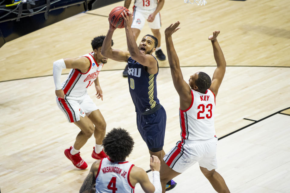 Oral Roberts' Kevin Obanor (0) goes up for a shot between Ohio State's Justice Sueing (14), Duane Washington Jr. (4) and Zed Key (23) during the first half of a first round game in the NCAA men's college basketball tournament, Friday, March 19, 2021, at Mackey Arena in West Lafayette, Ind. (AP Photo/Robert Franklin)