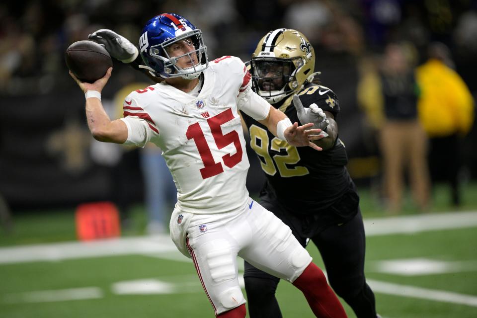 New York Giants quarterback Tommy DeVito (15) throws under pressure from New Orleans Saints defensive end Tanoh Kpassagnon (92) during the second half of an NFL football game Sunday, Dec. 17, 2023, in New Orleans. (AP Photo/Matthew Hinton)