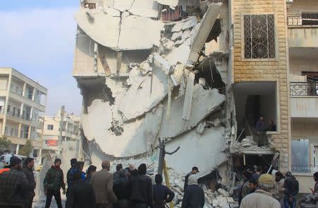 People inspect a site hit by what activists said were airstrikes carried out by the Russian air force in Idlib city, Syria December 20, 2015. REUTERS/Ammar Abdullah