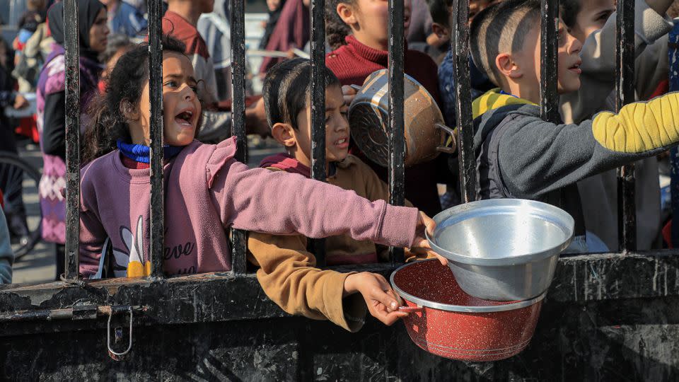 Children try to get food relief in the southern Gaza Strip city of Rafah, on December 31, 2023. - Rizek Abdeljawad/Xinhua/Getty Images
