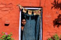 A leprosy patient looks out of her living quarters in a leprosy colony in New Delhi