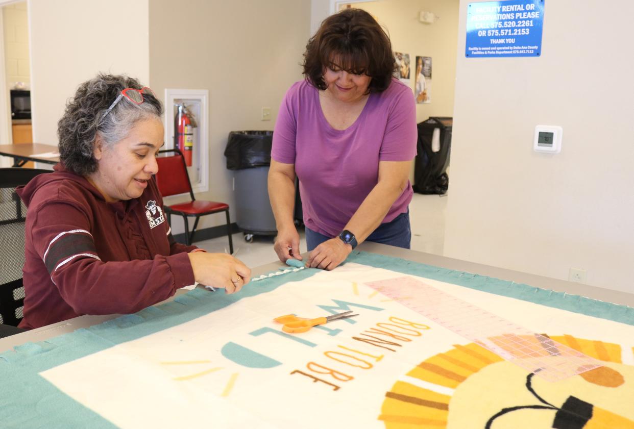 Inez Herrera, left, and Alma Renteria, both Doña Ana County promotoras, practice a blanket-making technique taught at one of a number of classes offered to residents at community centers in the outlying areas. Promotoras, or community health workers, have helped residents in rural areas navigate the challenges of the COVID-19 pandemic and its aftermath.