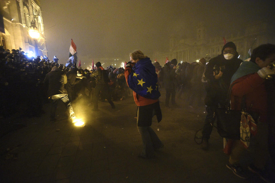 Protesters demonstrate against the amendments to the labour code, dubbed "slave law" by oppositional forces, at the parliament building in Budapest, Hungary, Thursday, Dec. 13, 2018. The rally, which was announced by the Free University and Students Trade Union student groups, started peacefully but police later responded to aggressive protestors with teargas. (Zoltan Balogh/MTI via AP)