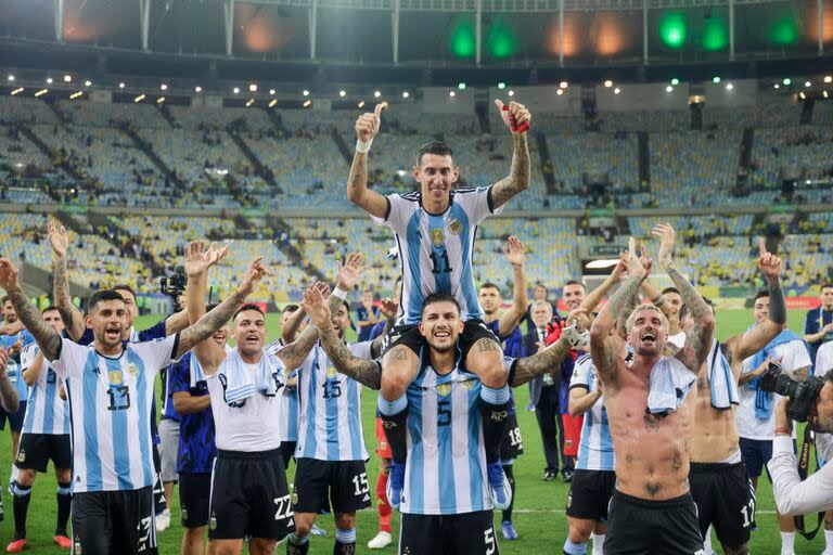 Ángel Di María en andas de Leandro Paredes frente a los hinchas argentinos; 