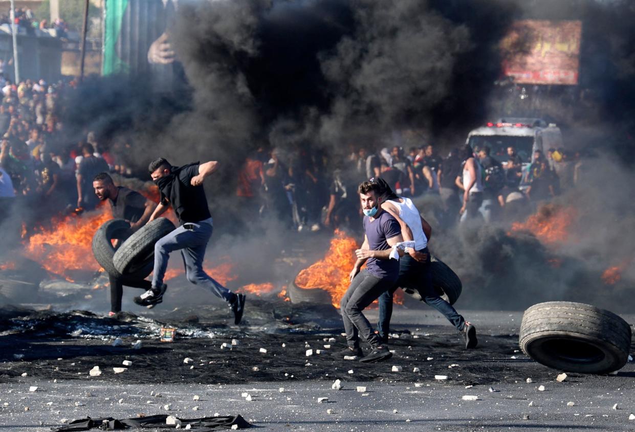 Palestinian protesters confront Israeli troops at the Hawara checkpoint south of Nablus city in the occupied West Bank (AFP via Getty Images)