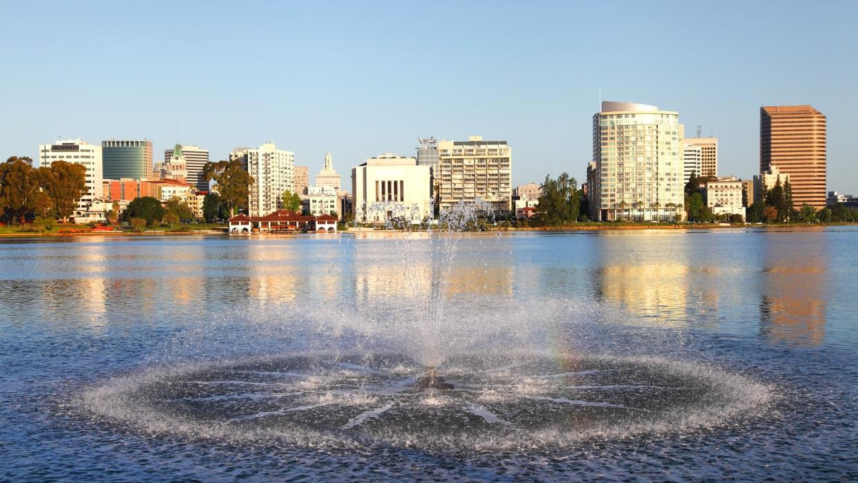 Downtown Oakland skyline along the banks of Lake Merritt .