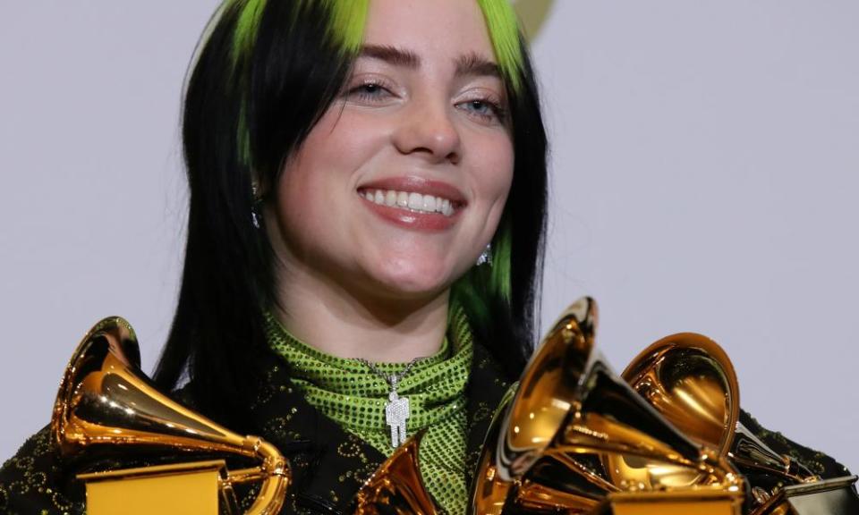 Billie Eilish posing with her Grammys haul in 2020.